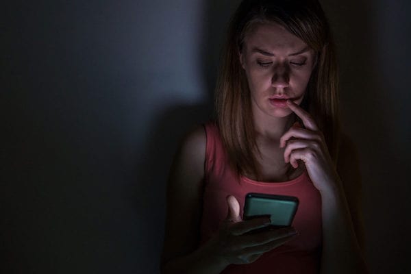 woman using her phone in the dark