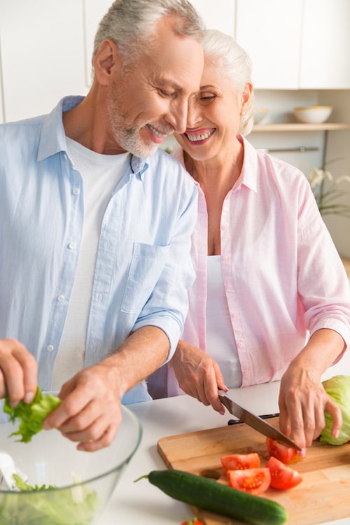older couple cooking together in kitchen