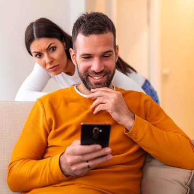 woman looking at man's phone over his shoulder