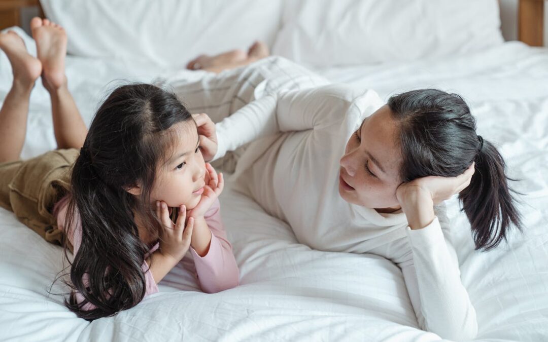 woman laying on bed with daughter