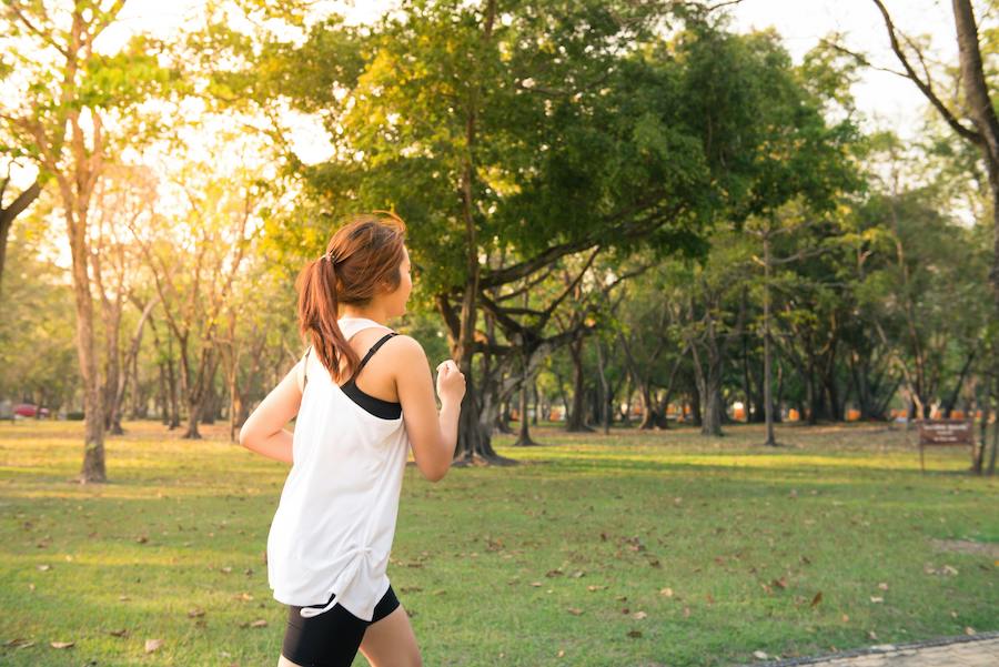 woman jogging in park on bright day