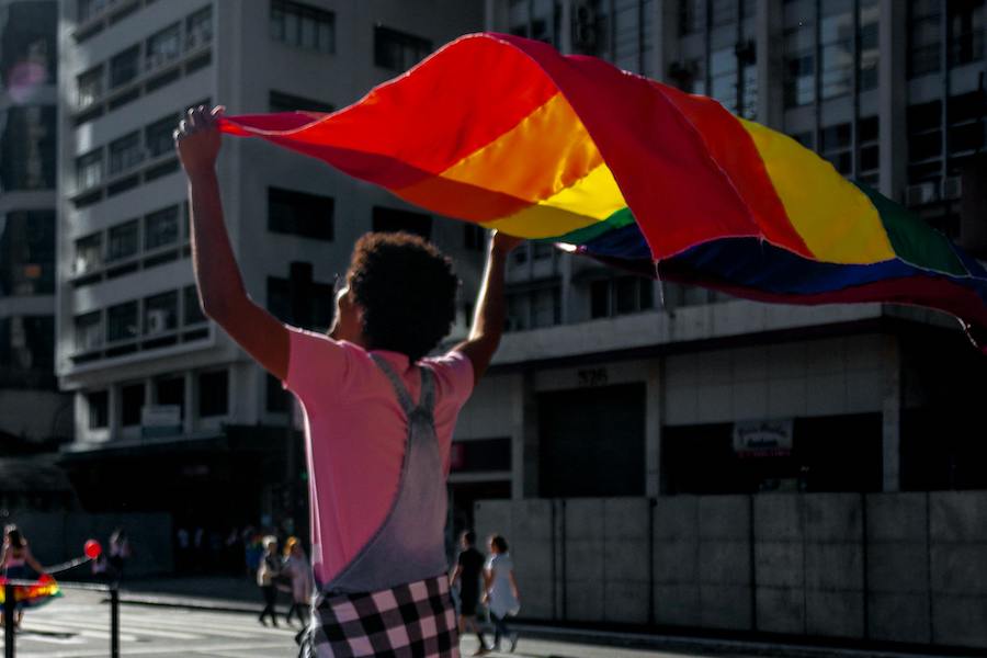 person holding large pride flag above their head