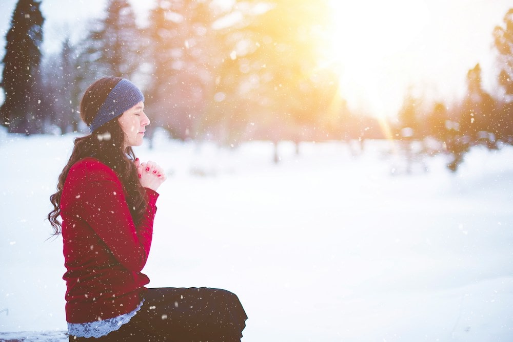 woman sitting outside in snow