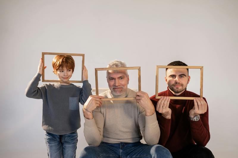 three generations next to each other with frames held around their faces