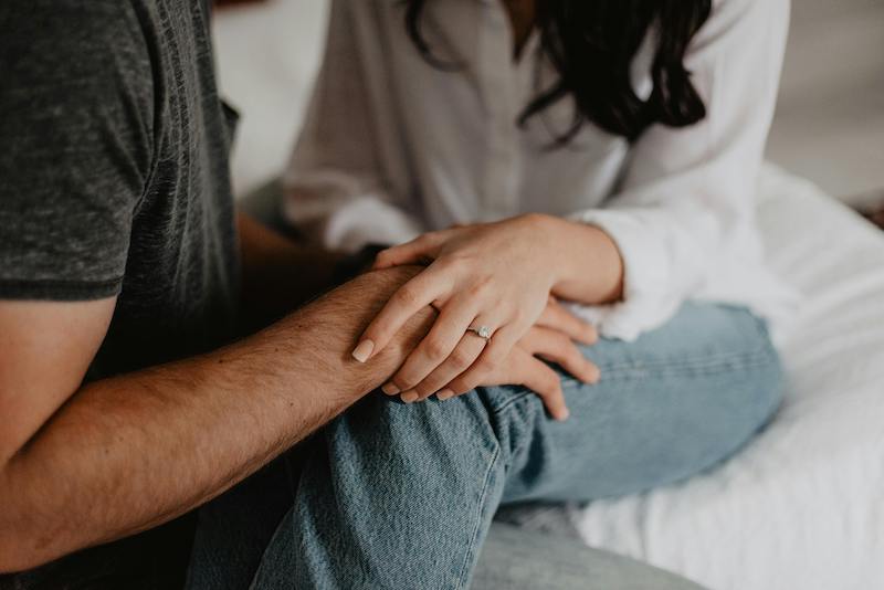 woman with hand on man's in supportive gesture