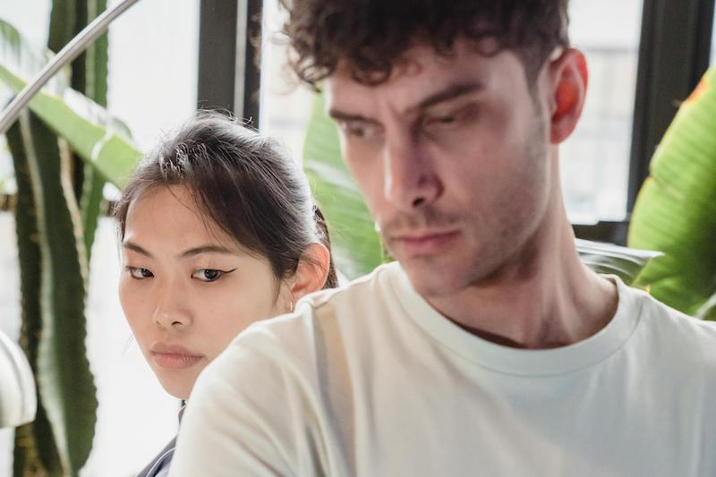 couple standing next to each other both looking angry