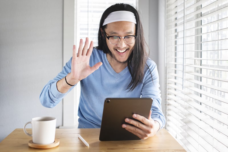 man talking to partner on tablet smiling