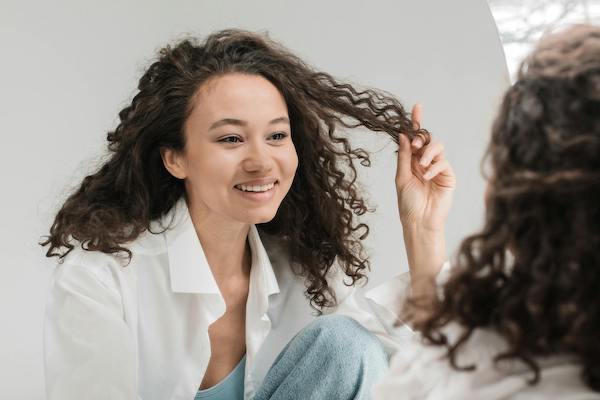 woman looking in the mirror and smiling at her reflection