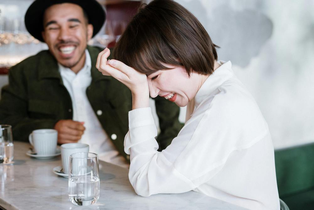 happy couple laughing sharing coffee together