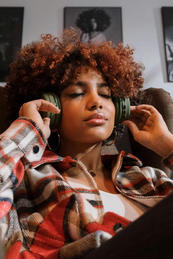woman listening to headphones in comfortable chair