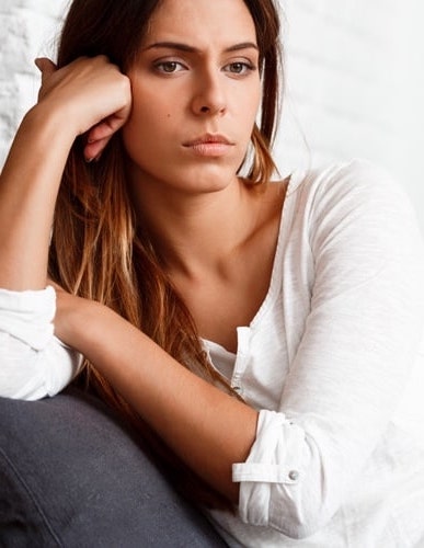 woman sitting on sofa looking serious