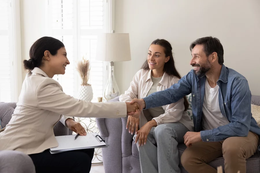 A couple shakes a therapist’s hand before their first therapy session.